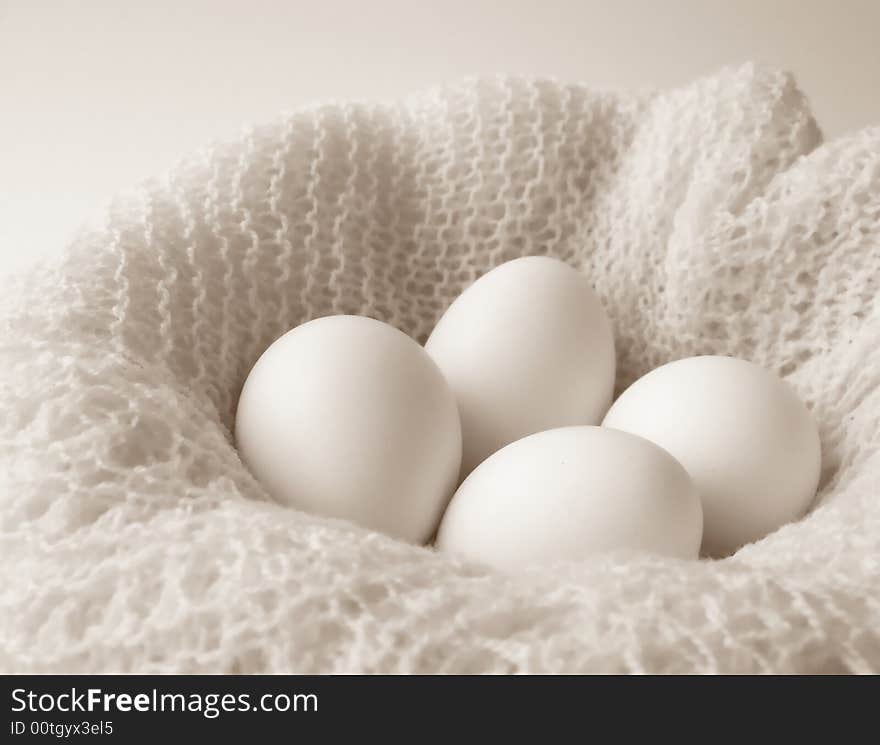 Image of four white eggs sitting in a bowl covered with a finely crocheted shawl.  Black and white with horizontal orientation. Image of four white eggs sitting in a bowl covered with a finely crocheted shawl.  Black and white with horizontal orientation.