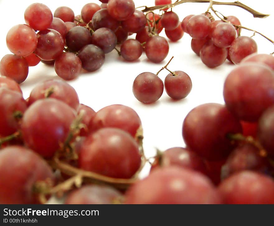 Image of red grapes forming a ring around two joined together.  White background.  Horizontal orientation. Image of red grapes forming a ring around two joined together.  White background.  Horizontal orientation.