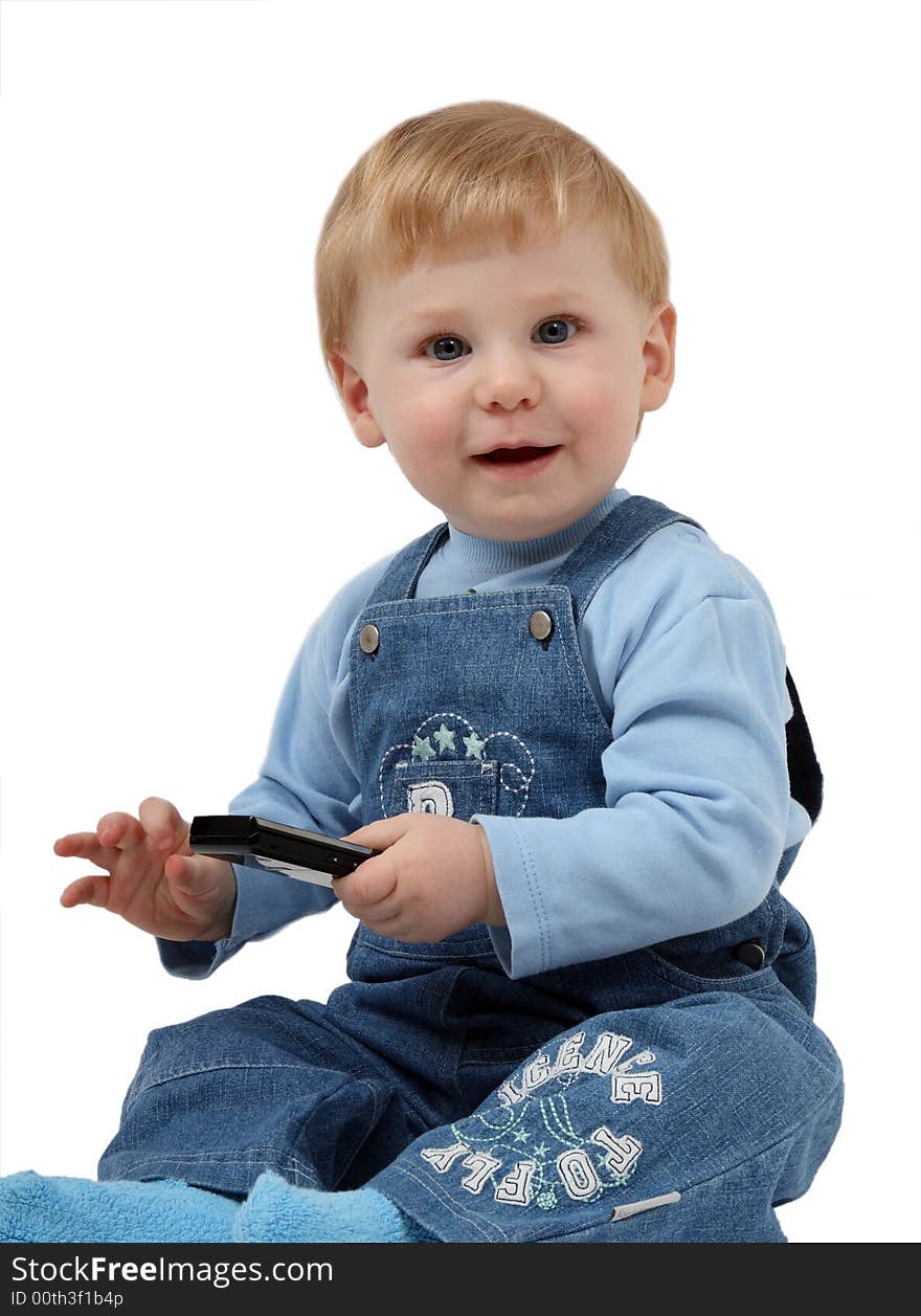 The small beautiful boy laughs and sits at a mobile phone in hands. The small beautiful boy laughs and sits at a mobile phone in hands