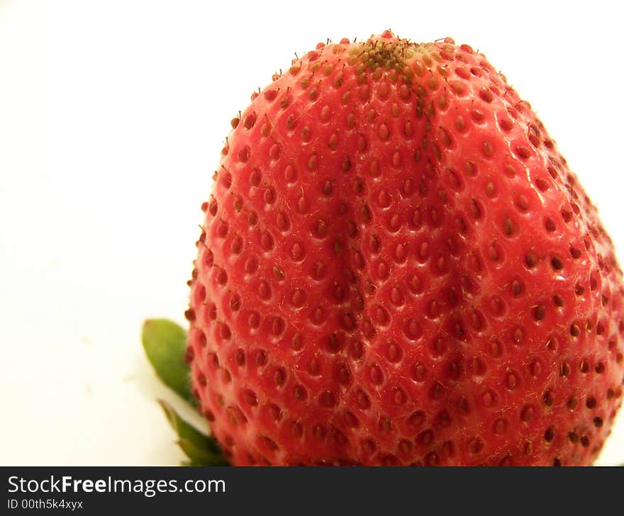 Close up image of an large, bright red strawberry, turned upside down.  Room for text or other material remains at left of image.  White background and horizontal orientation. Close up image of an large, bright red strawberry, turned upside down.  Room for text or other material remains at left of image.  White background and horizontal orientation.