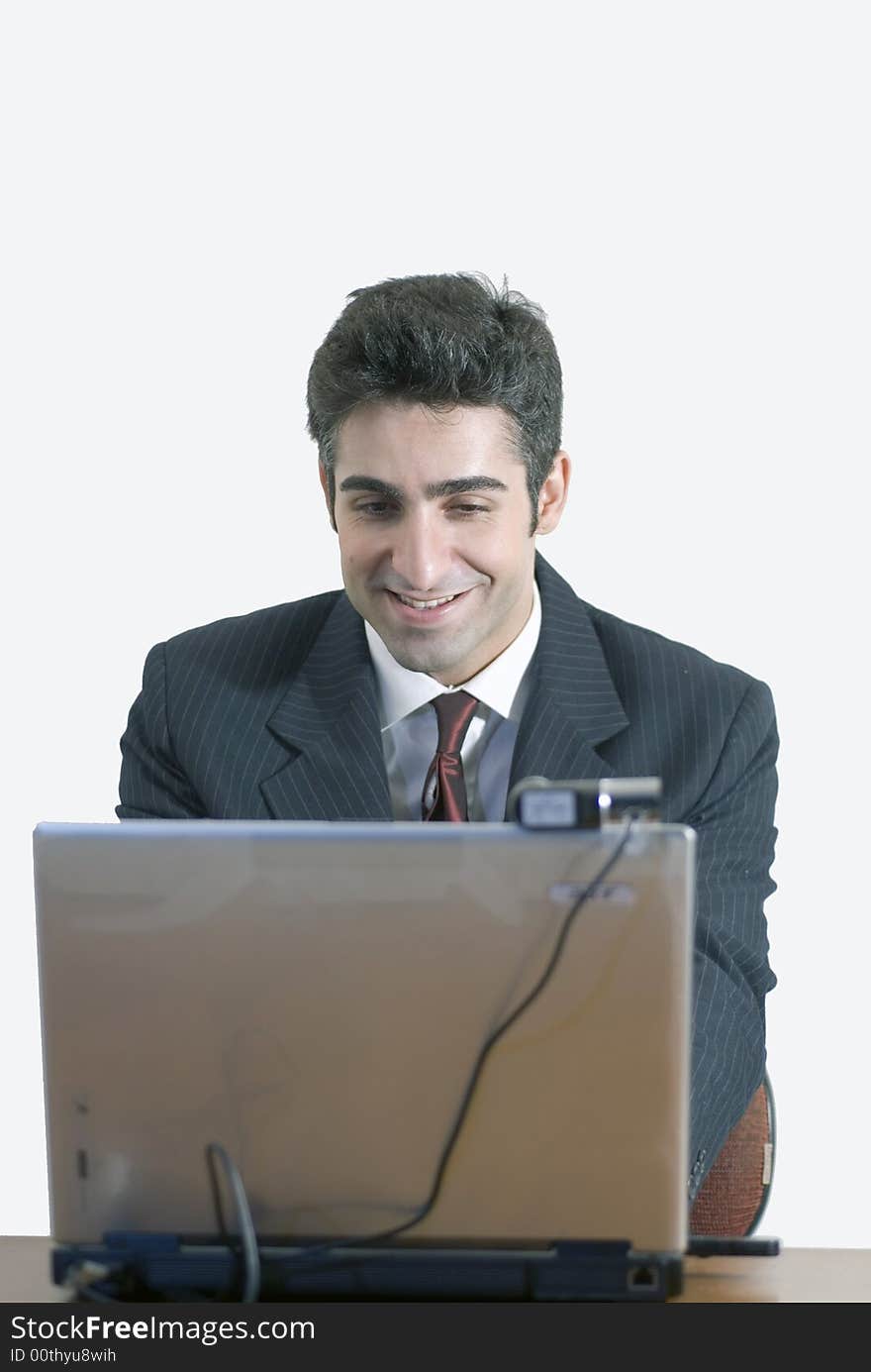 Business man at laptop with a contented smile. Business man at laptop with a contented smile