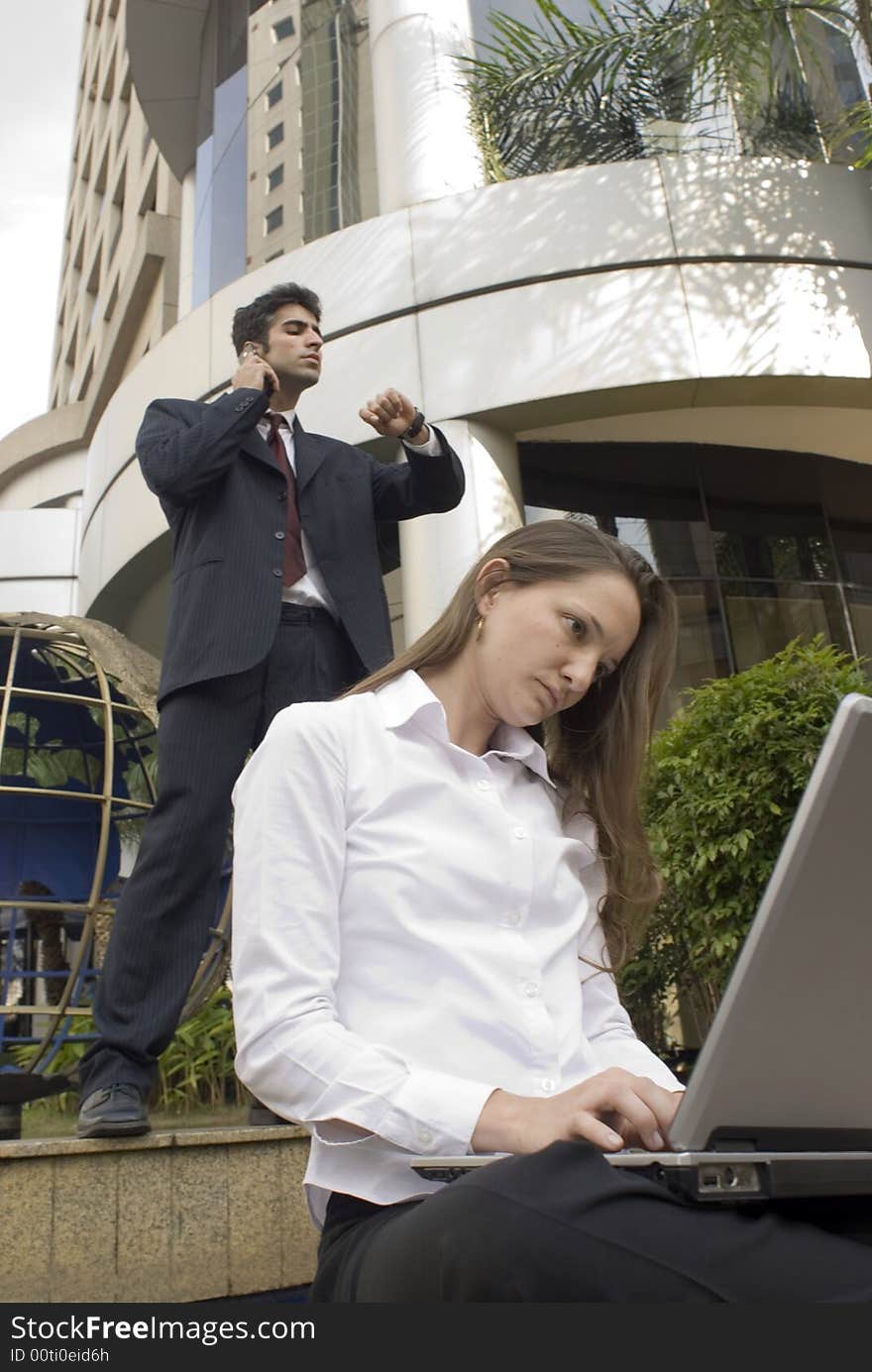 Man and woman in business attire working together. Man and woman in business attire working together