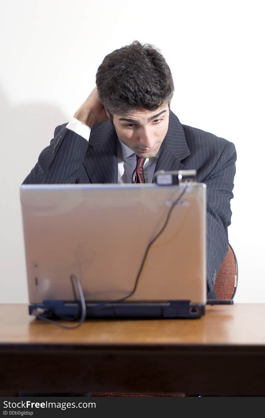 Fed up business man working at a desk. Isolated against a white background. Fed up business man working at a desk. Isolated against a white background