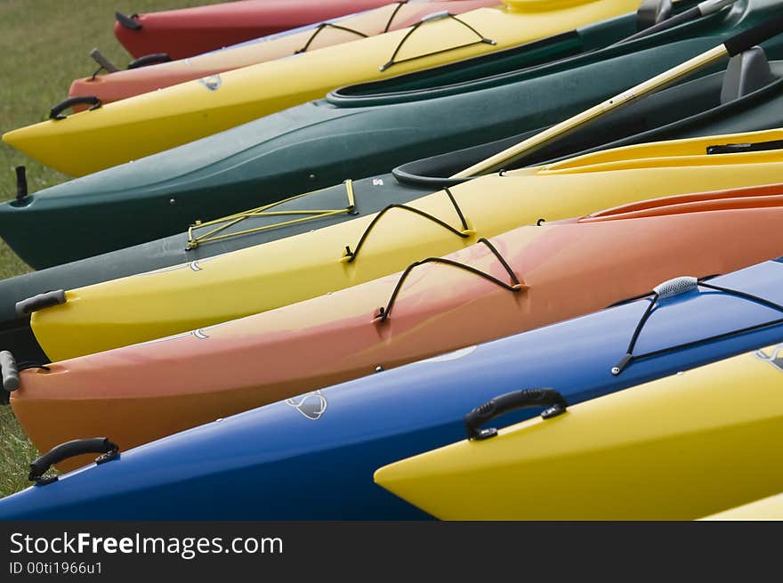 A colorful group of kayaks on the shore. A colorful group of kayaks on the shore.