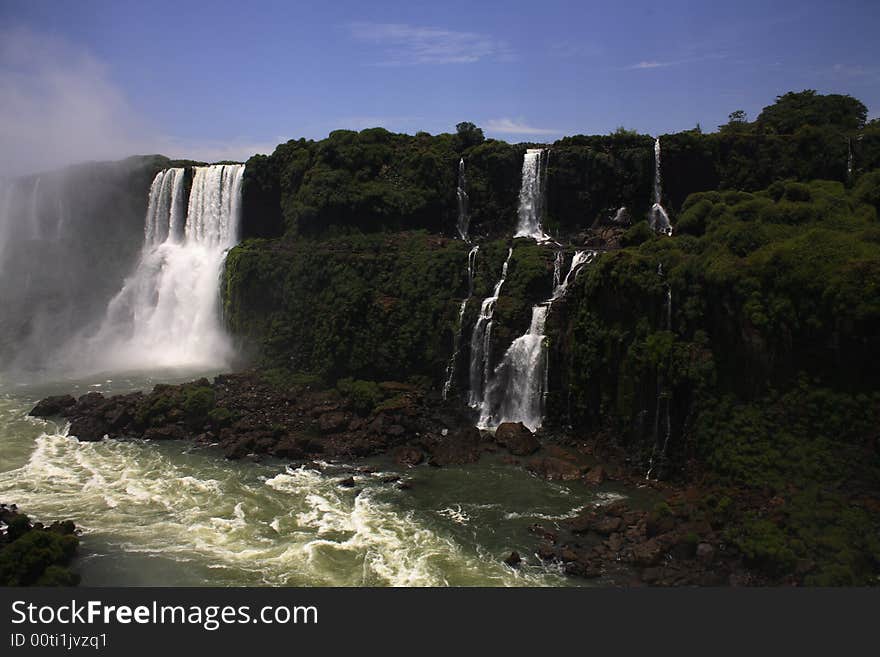 The Iguassu (or Iguazu) Falls is one of the largest masses of fresh water on the planet and divides, in South America, Brazil, Paraguay and Argentina. The waterfall system consists of 275 falls along 2.7 kilometres (1.67 miles) of the Iguazu River. Some of the individual falls are up to 82 metres (269 feet) in height, though the majority are about 64 metres (210 feet). The Iguassu (or Iguazu) Falls is one of the largest masses of fresh water on the planet and divides, in South America, Brazil, Paraguay and Argentina. The waterfall system consists of 275 falls along 2.7 kilometres (1.67 miles) of the Iguazu River. Some of the individual falls are up to 82 metres (269 feet) in height, though the majority are about 64 metres (210 feet).