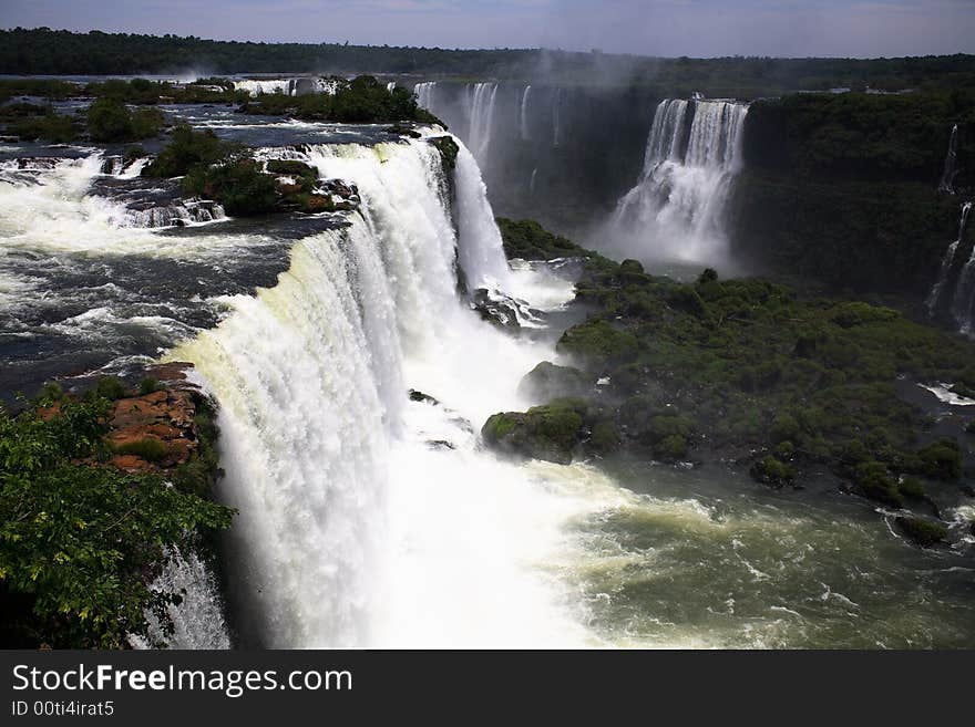 The Iguassu (or Iguazu) Falls is one of the largest masses of fresh water on the planet and divides, in South America, Brazil, Paraguay and Argentina. The waterfall system consists of 275 falls along 2.7 kilometres (1.67 miles) of the Iguazu River. Some of the individual falls are up to 82 metres (269 feet) in height, though the majority are about 64 metres (210 feet). The Iguassu (or Iguazu) Falls is one of the largest masses of fresh water on the planet and divides, in South America, Brazil, Paraguay and Argentina. The waterfall system consists of 275 falls along 2.7 kilometres (1.67 miles) of the Iguazu River. Some of the individual falls are up to 82 metres (269 feet) in height, though the majority are about 64 metres (210 feet).