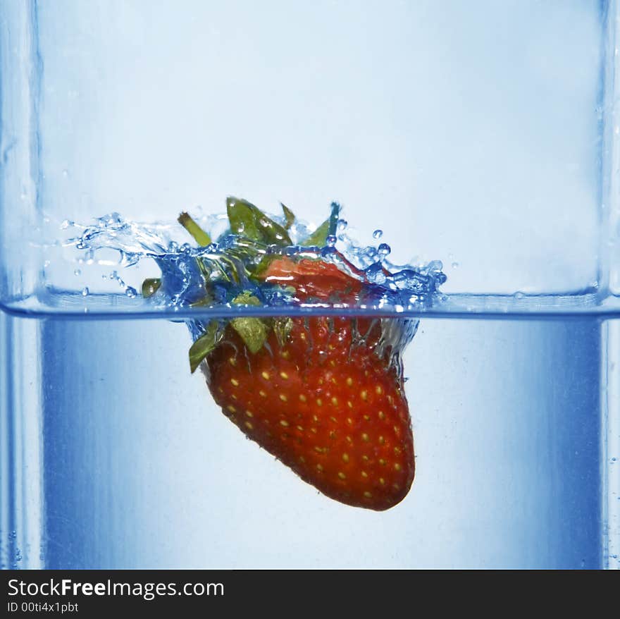 Splashing strawberry into a water. Splashing strawberry into a water