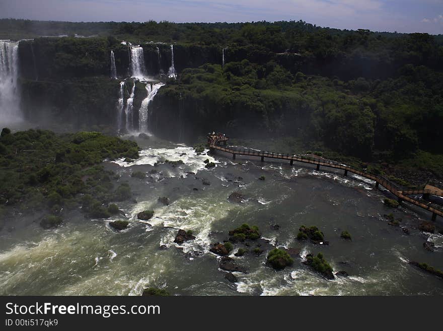 The Iguassu (or Iguazu) Falls is one of the largest masses of fresh water on the planet and divides, in South America, Brazil, Paraguay and Argentina. The waterfall system consists of 275 falls along 2.7 kilometres (1.67 miles) of the Iguazu River. Some of the individual falls are up to 82 metres (269 feet) in height, though the majority are about 64 metres (210 feet). The Iguassu (or Iguazu) Falls is one of the largest masses of fresh water on the planet and divides, in South America, Brazil, Paraguay and Argentina. The waterfall system consists of 275 falls along 2.7 kilometres (1.67 miles) of the Iguazu River. Some of the individual falls are up to 82 metres (269 feet) in height, though the majority are about 64 metres (210 feet).