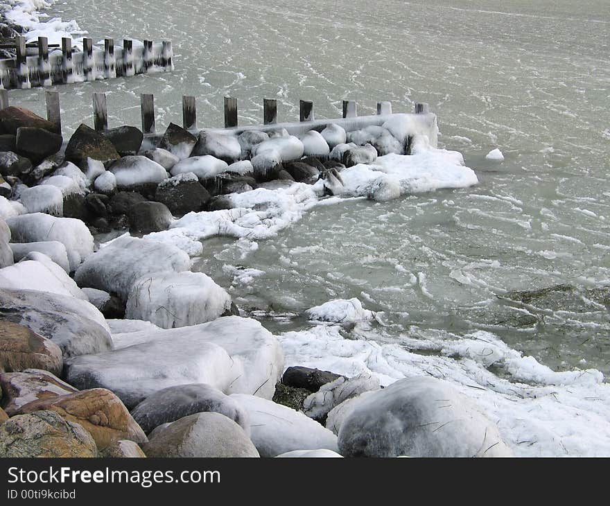 Frozen sea water by a wooden dock. Frozen sea water by a wooden dock