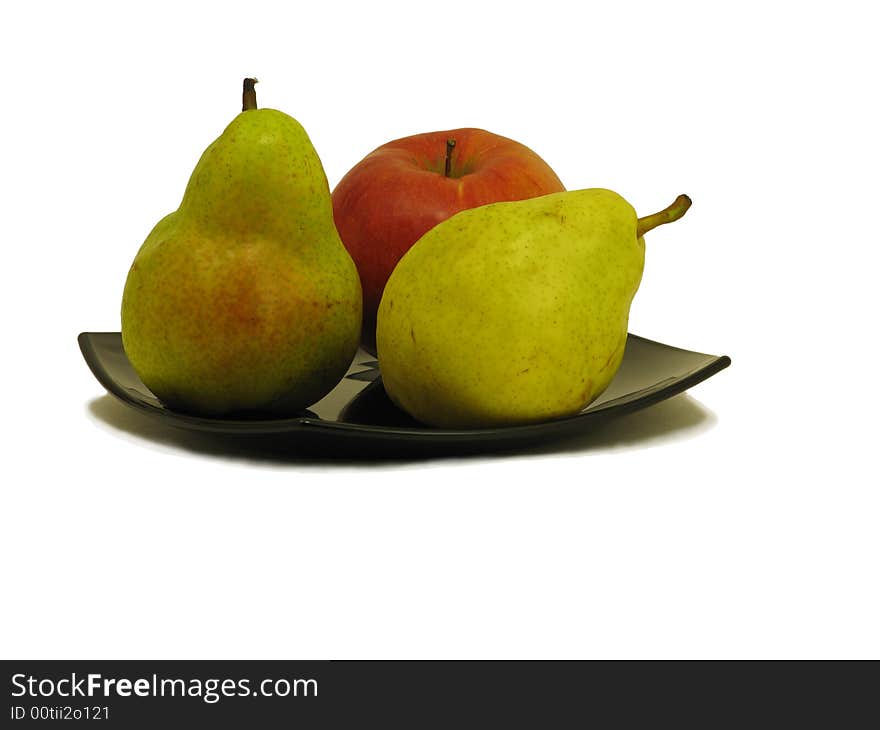 Two pears and apple on black dish isolated on white