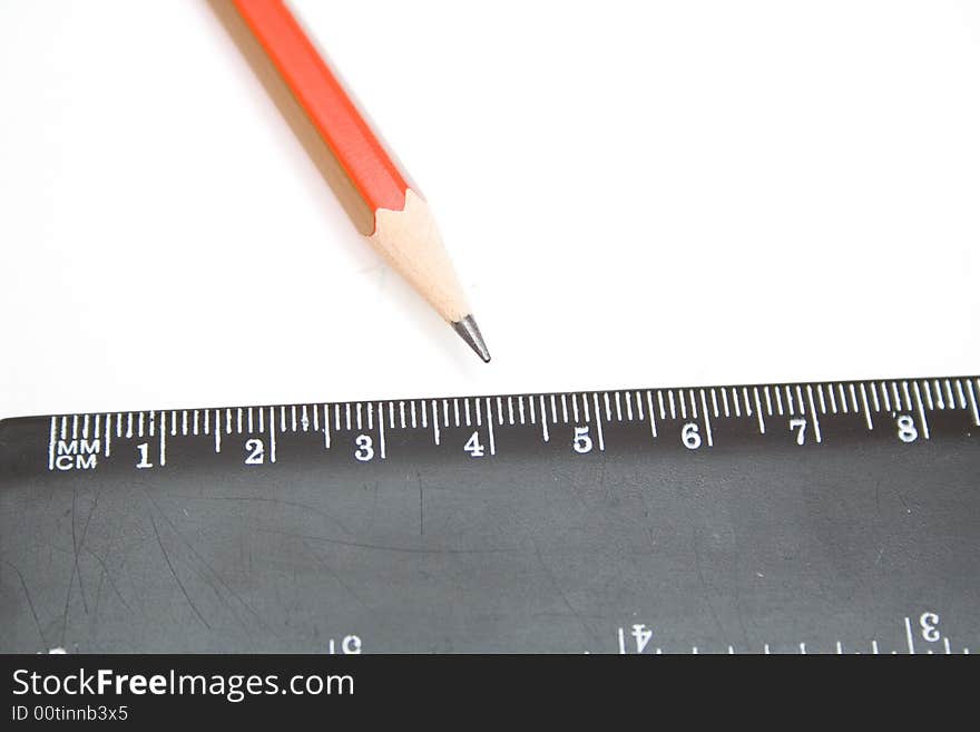 Pencil and black ruller on the white isolated background