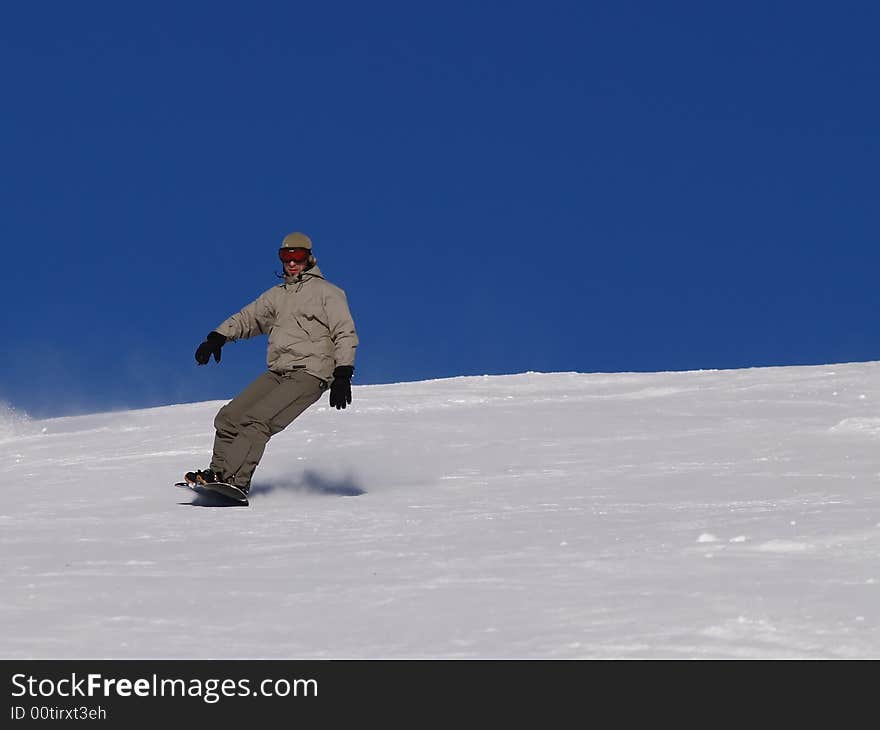 Snowboarder guy sliding on the slope.