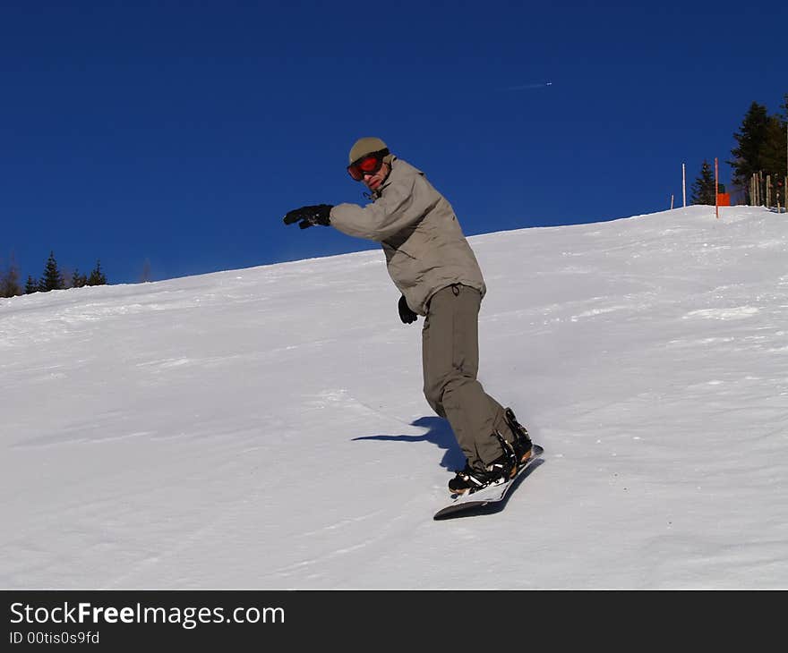 Snowboarder guy sliding on the slope.