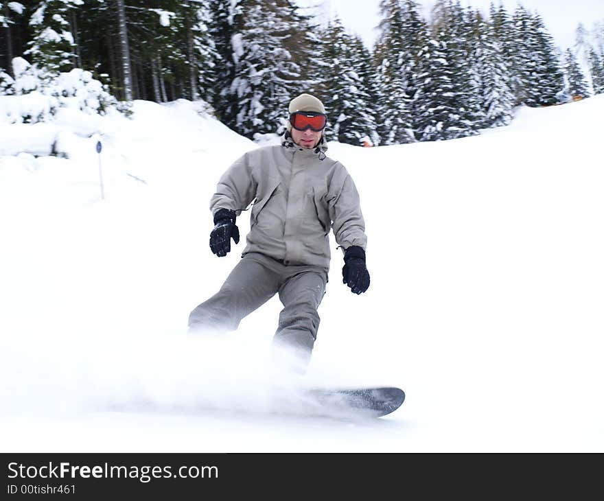 Snowboarder guy sliding on the slope.