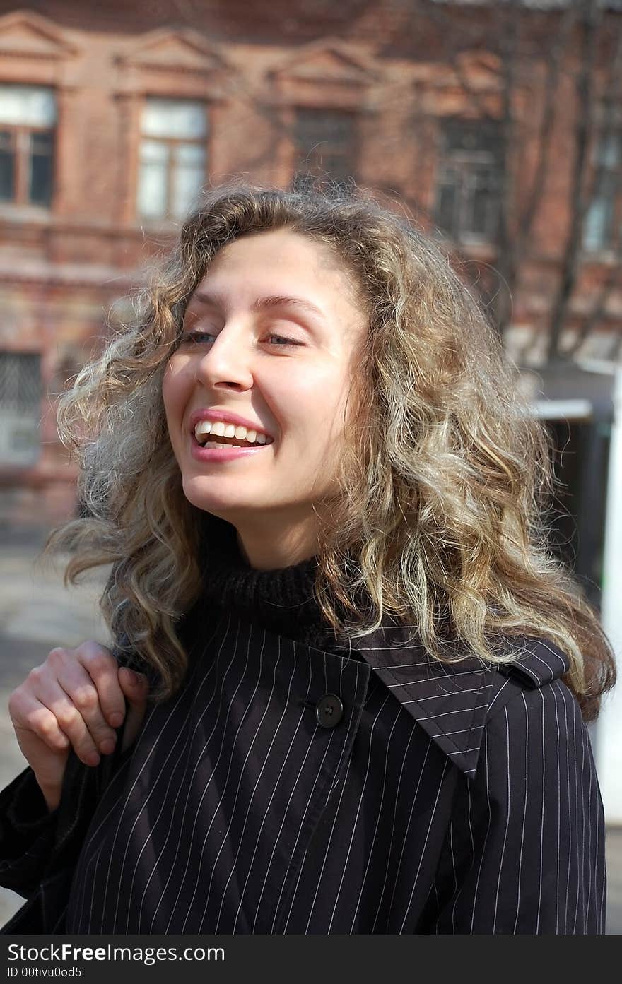 Happy spring girl in the strret near the old house