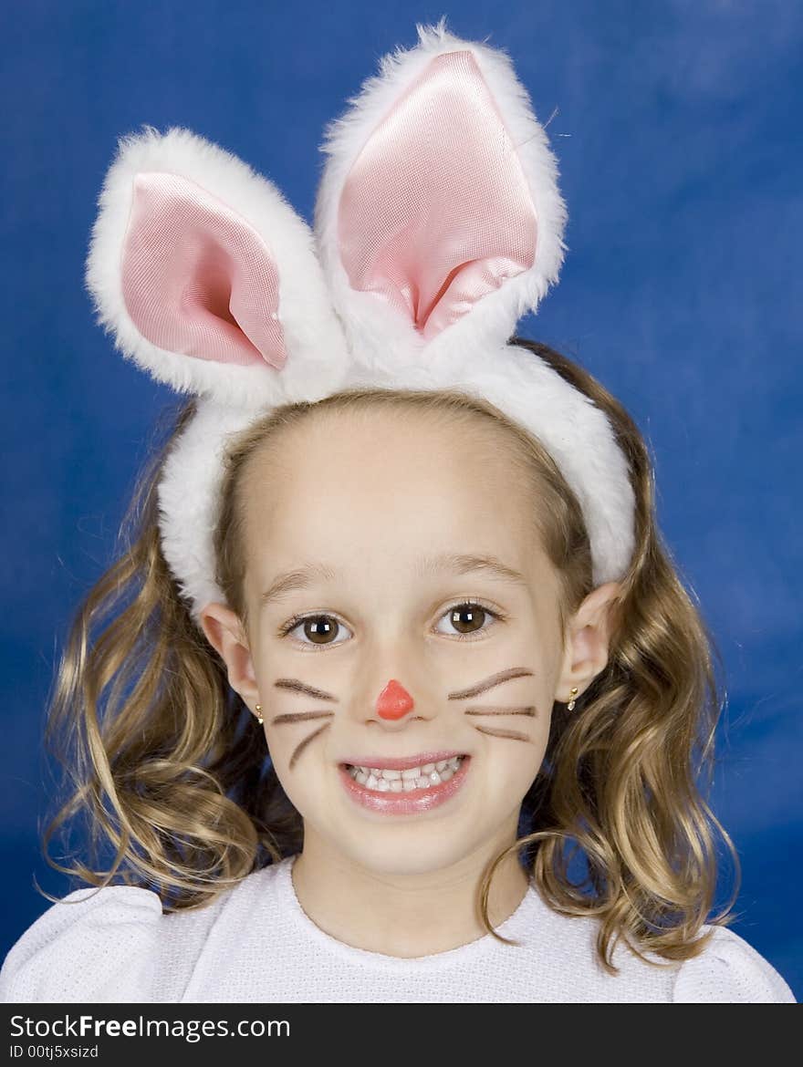 Little smilling girl with bunny ears over blue background