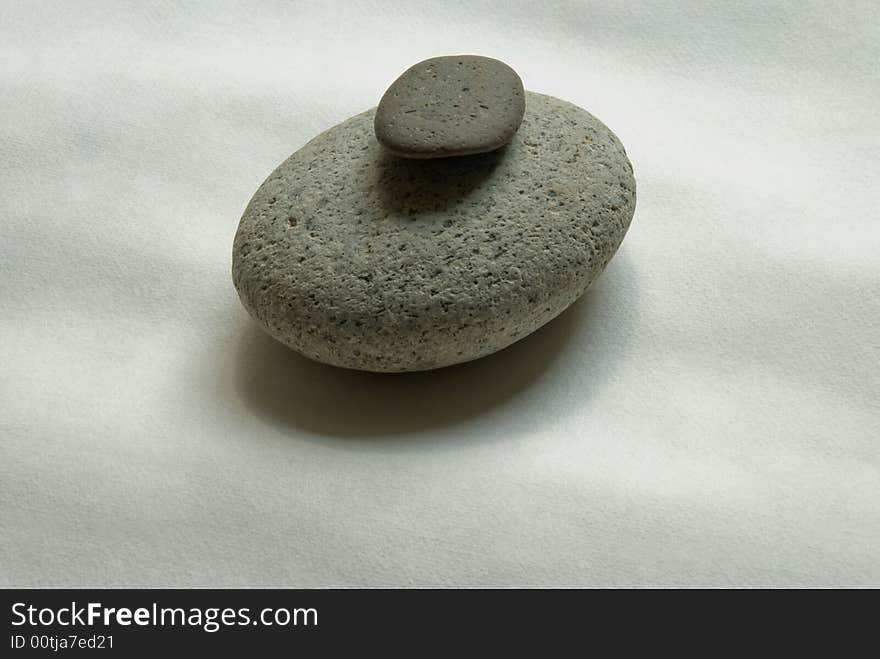 Two rounded stones on a piece of Japanese hand made paper. Two rounded stones on a piece of Japanese hand made paper