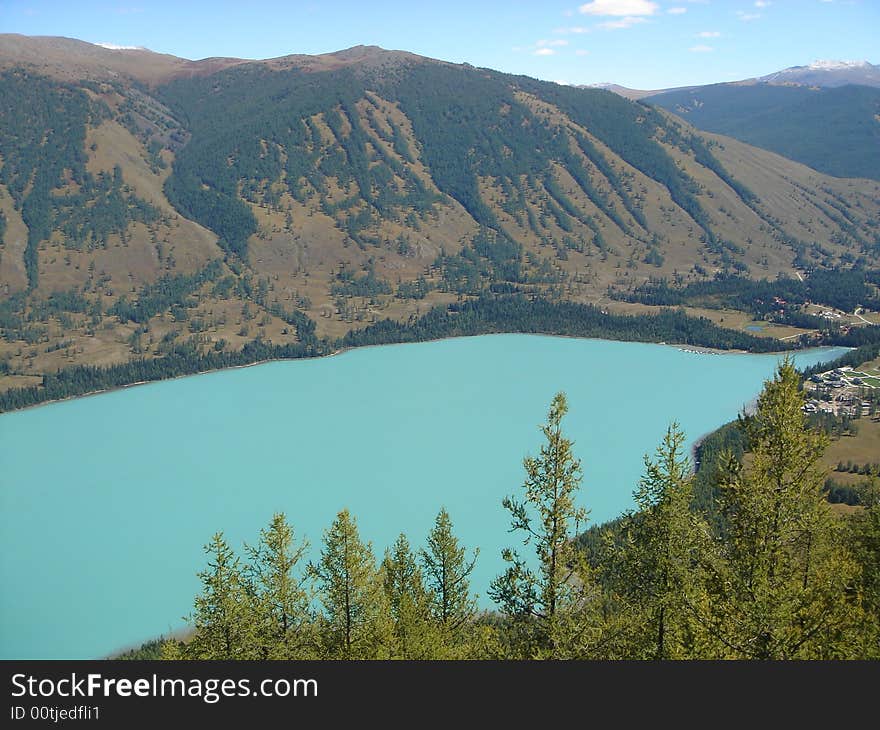 A beautiful blue lake surrounded by mountain and forests in the xing jiang province of china. A beautiful blue lake surrounded by mountain and forests in the xing jiang province of china.