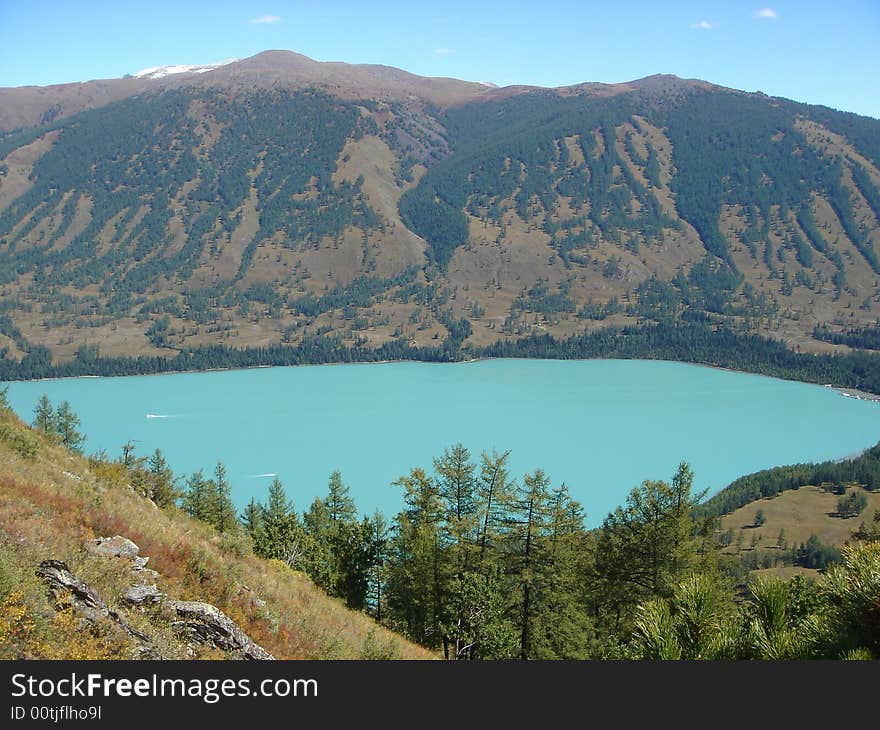 A beautiful blue lake surrounded by mountain and forests in the xing jiang province of china. A beautiful blue lake surrounded by mountain and forests in the xing jiang province of china.