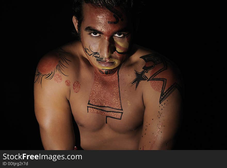 Portrait of latin young male with intense look and bodypaint drawing. Portrait of latin young male with intense look and bodypaint drawing