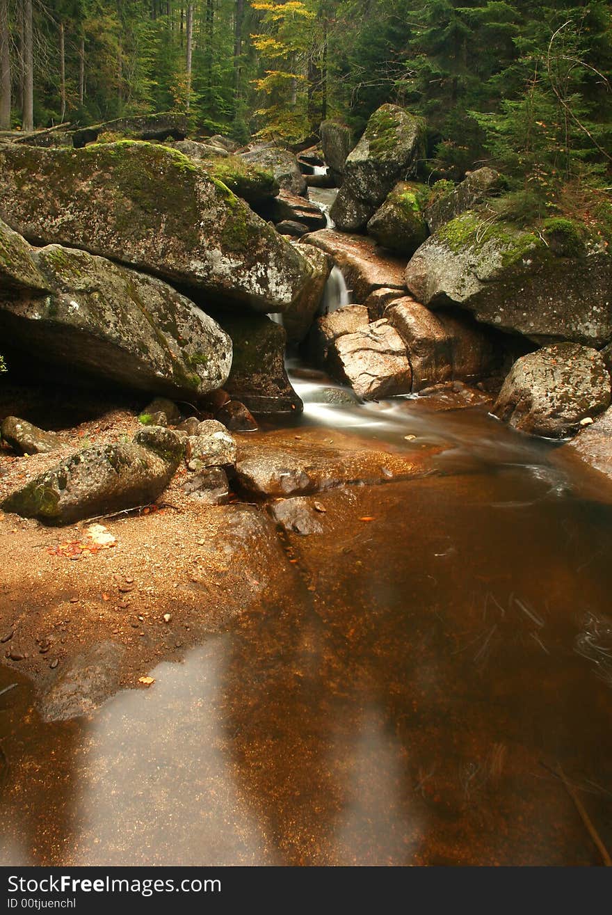 The water of a torrent flow between mountain rocks