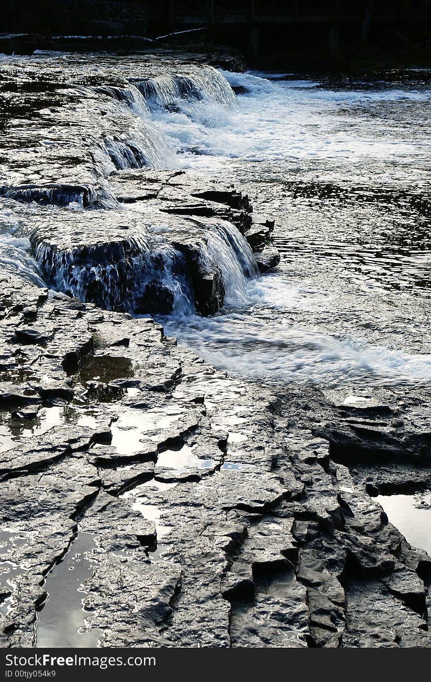 White water flowing over dark rocks in river. White water flowing over dark rocks in river