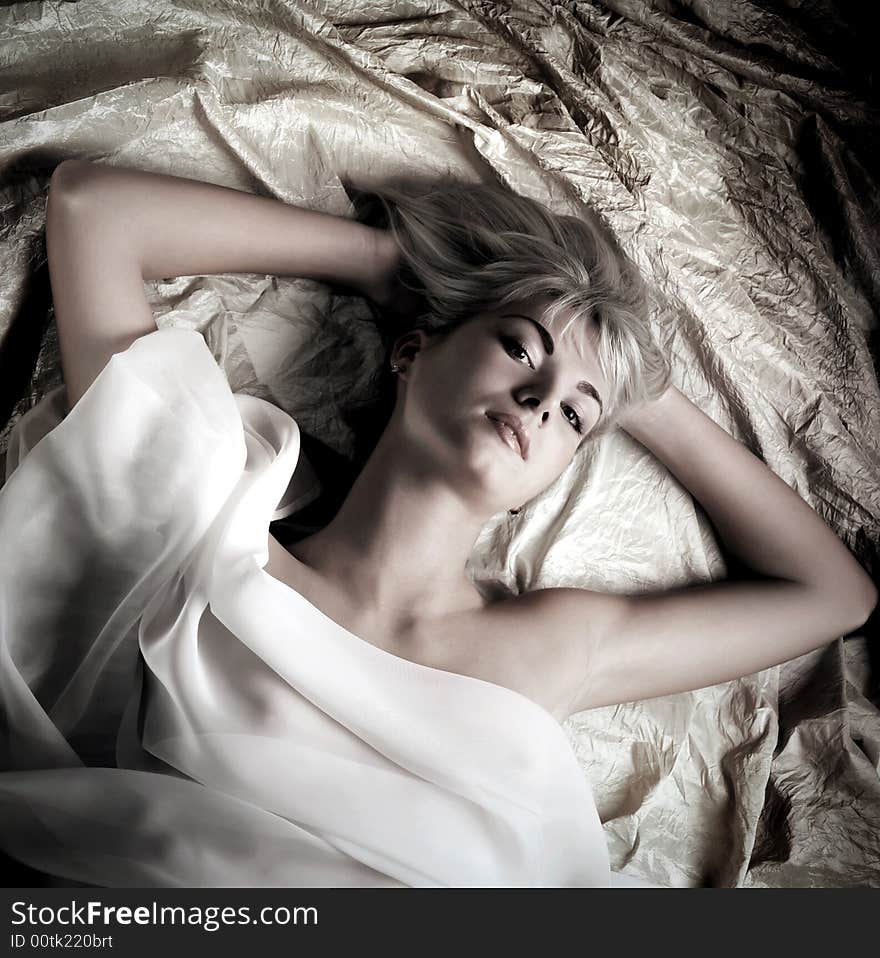 Monochrome portrait of a lovely beautiful girl lying in a bed