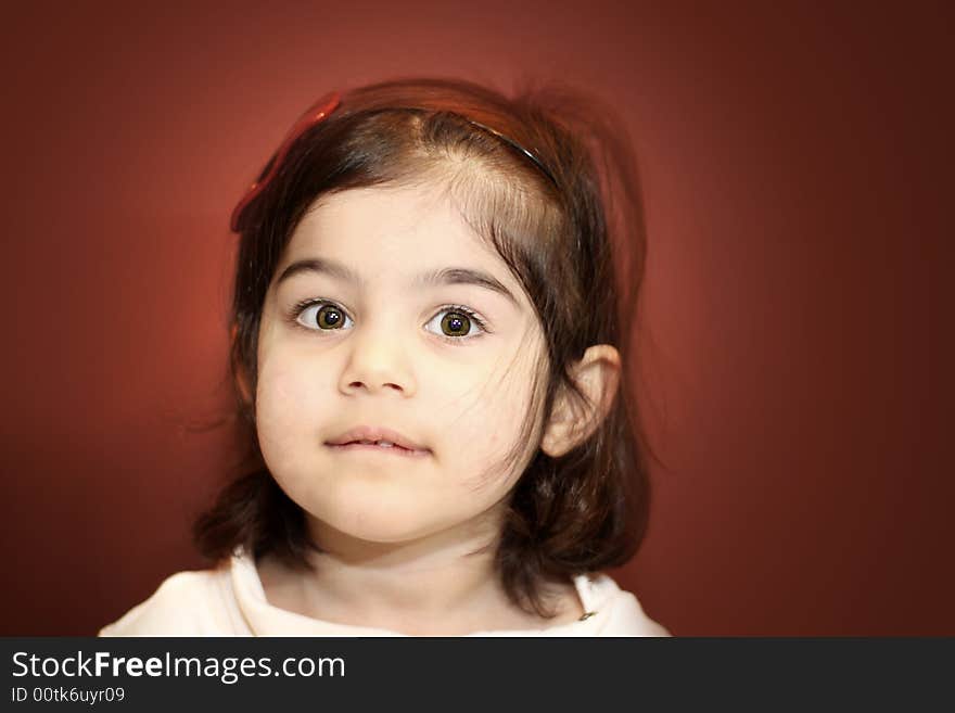 A close-up portrait of a two year old with a brown background. A close-up portrait of a two year old with a brown background