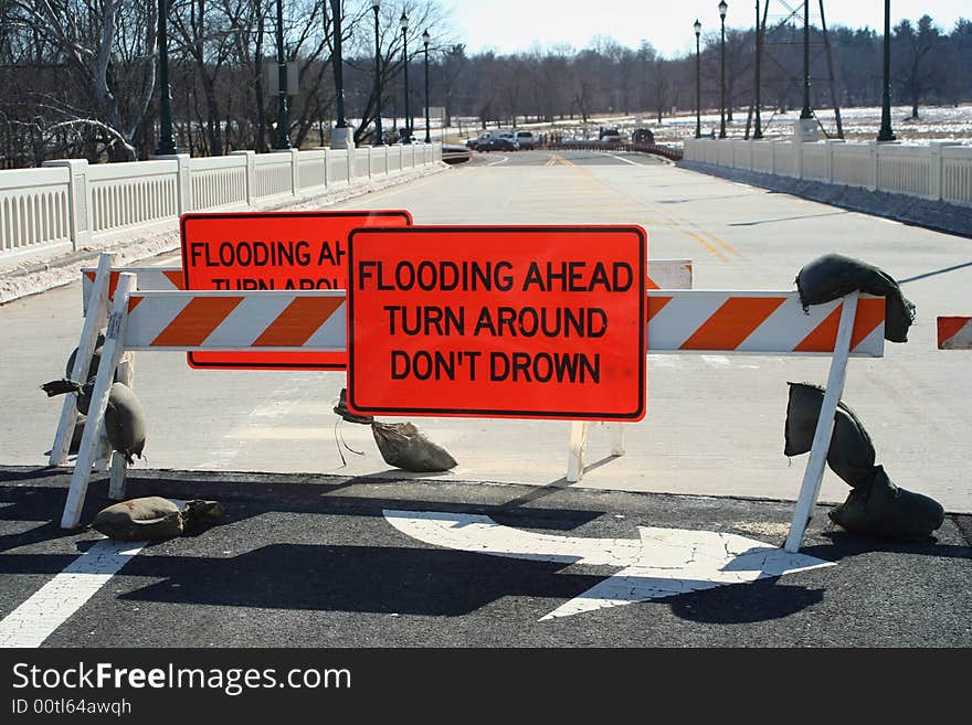 Flooded roadway sign on a bridge