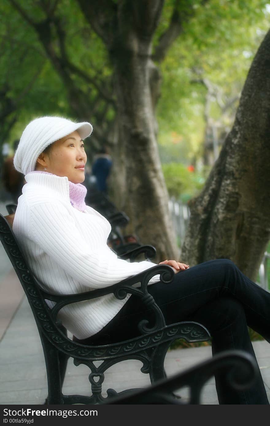 A chinese woman sit in a garden. A chinese woman sit in a garden