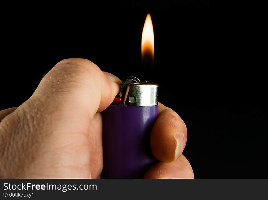 Lit cigarette lighter on dark background. Lit cigarette lighter on dark background