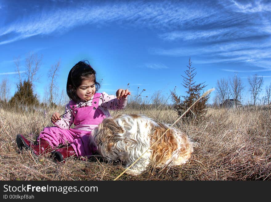 Toddler playing with her dogg in the field. Toddler playing with her dogg in the field