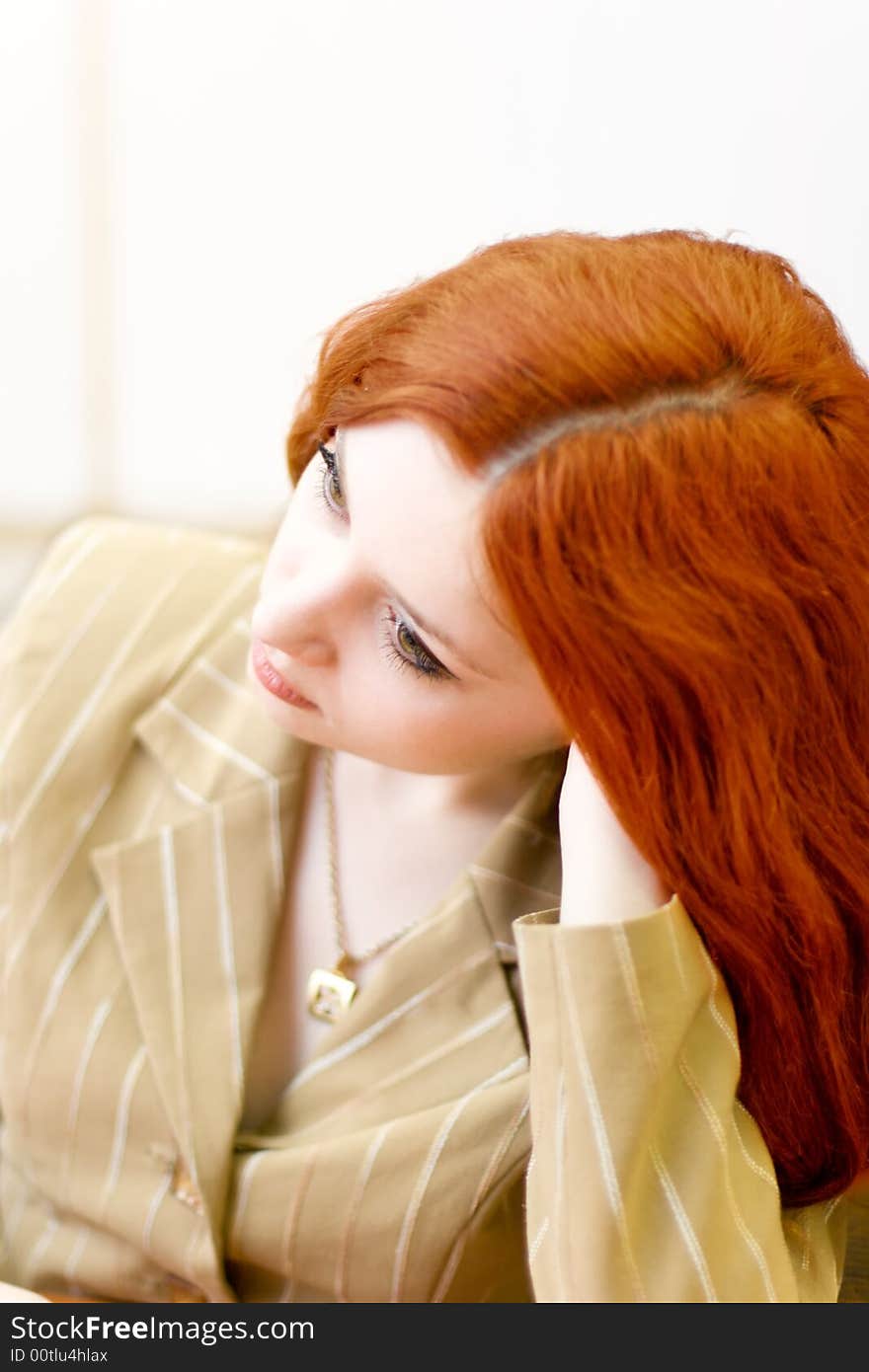 Melancholic redhead woman in classical suit sit down in office