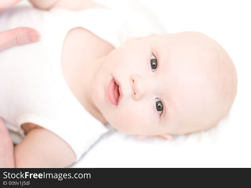 Mother care about baby. Boy lie on back and look at camera