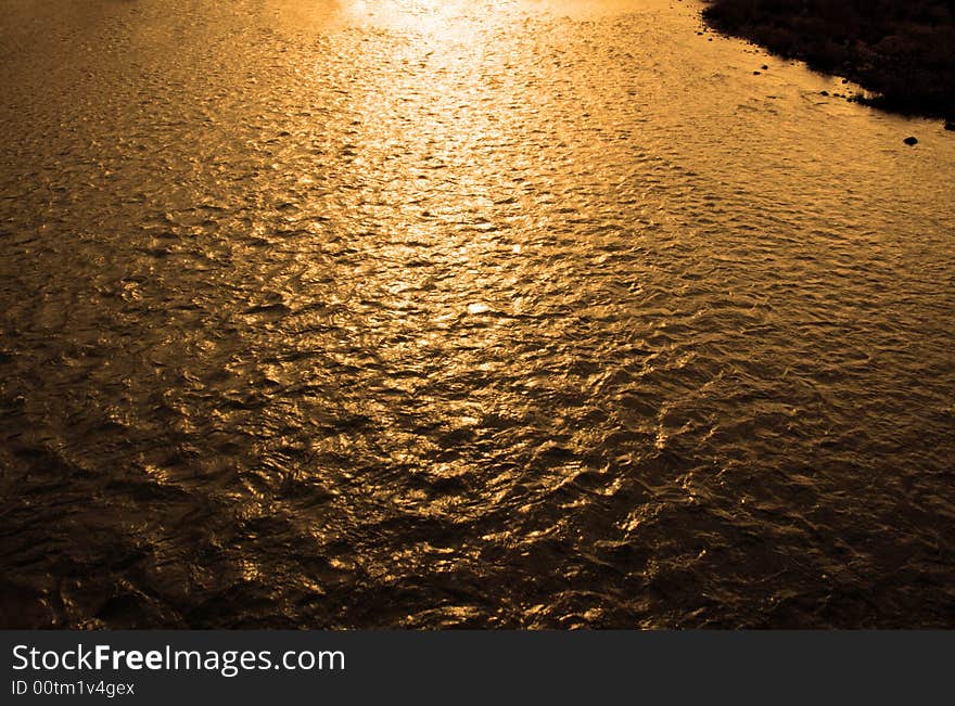 River at sunset making the water golden. River at sunset making the water golden.