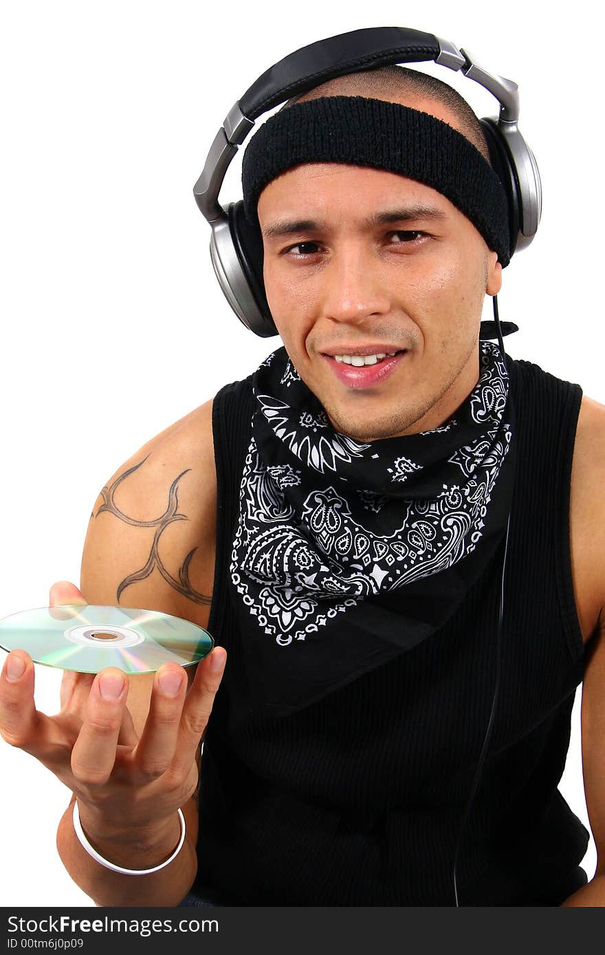 A young man with headphones in black with lots of tattoos is looking at a disc. A young man with headphones in black with lots of tattoos is looking at a disc.