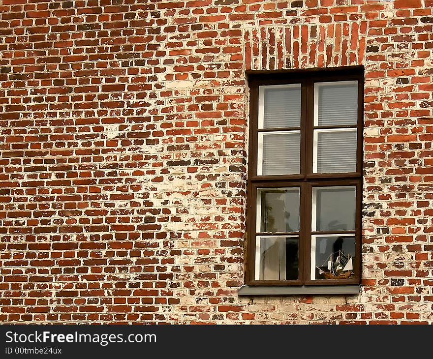 Toy ship in a window on a brick wall