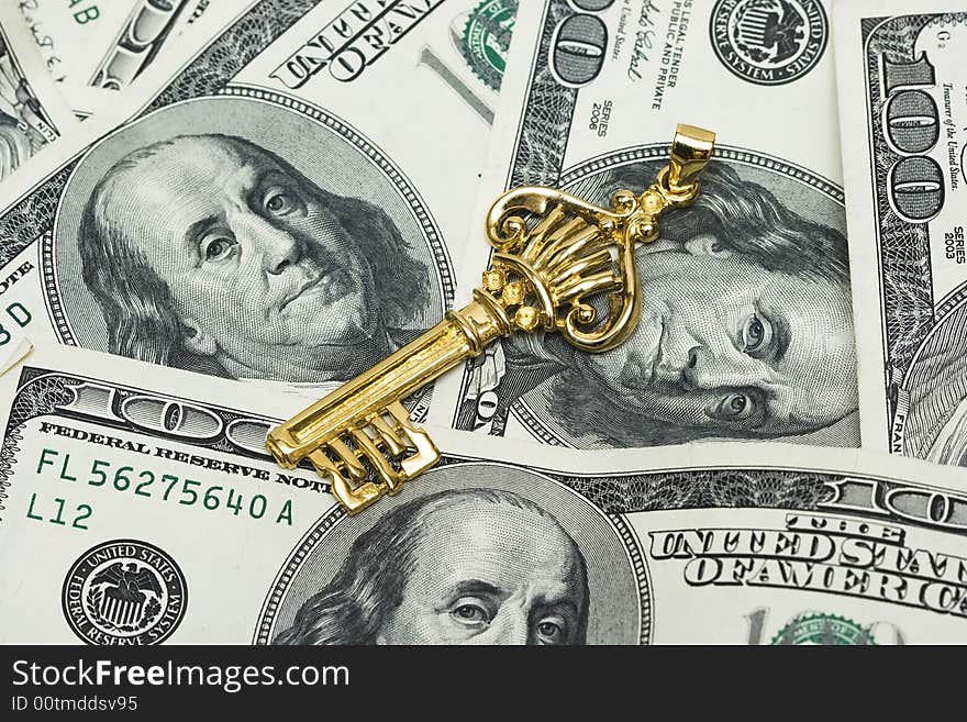 Golden key on dollars background