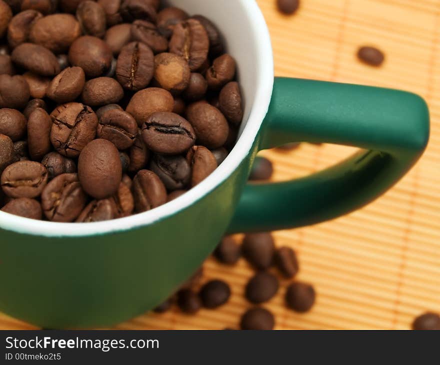 Coffee Beans In A Green Cup