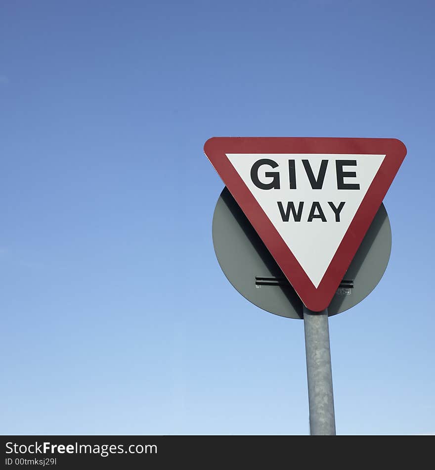 Give way sign with blue background sky