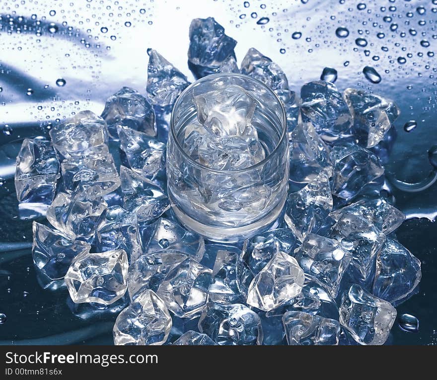 Glass with water and ice over blue