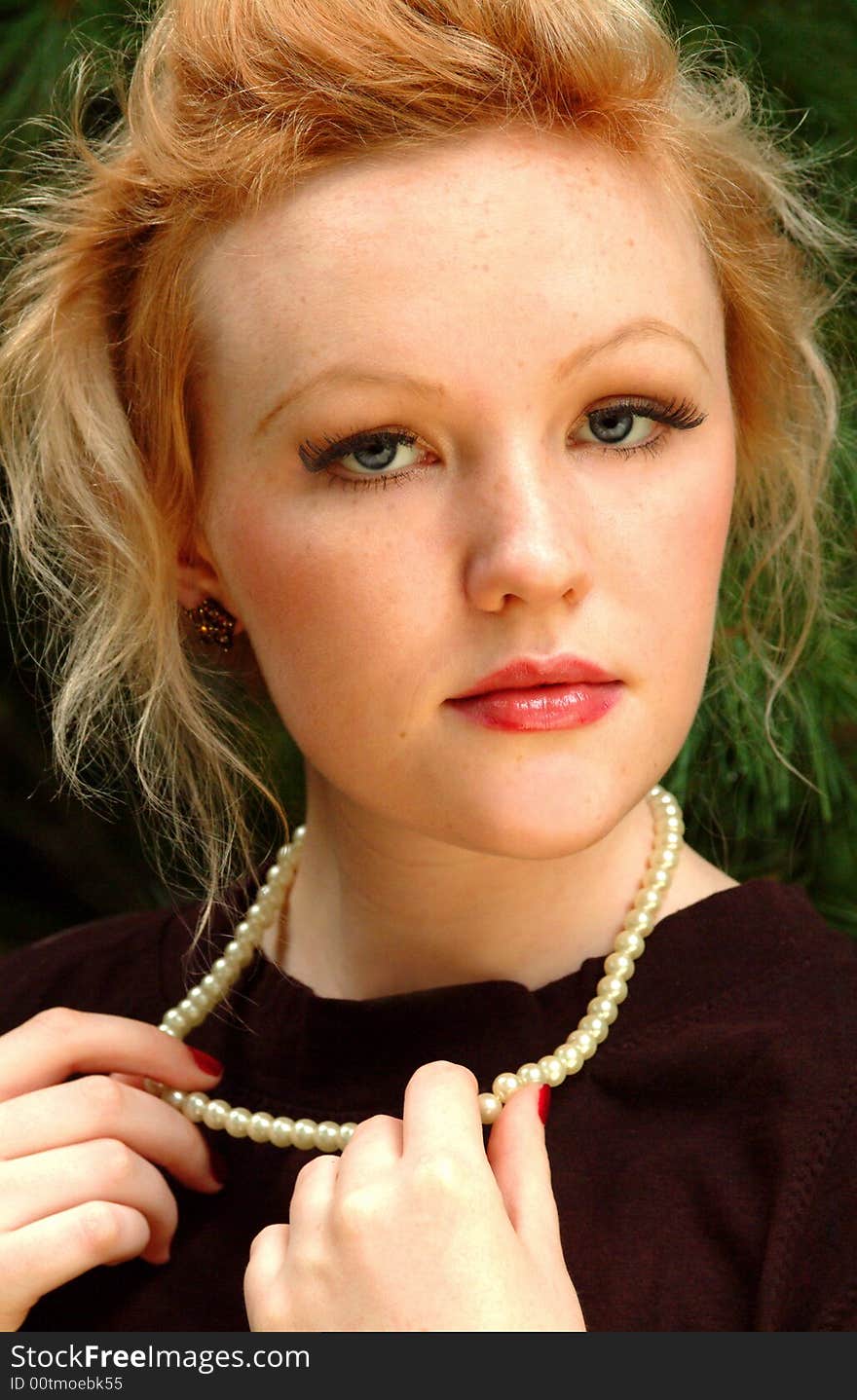 Young blond woman in outdoor location with pearls. Young blond woman in outdoor location with pearls