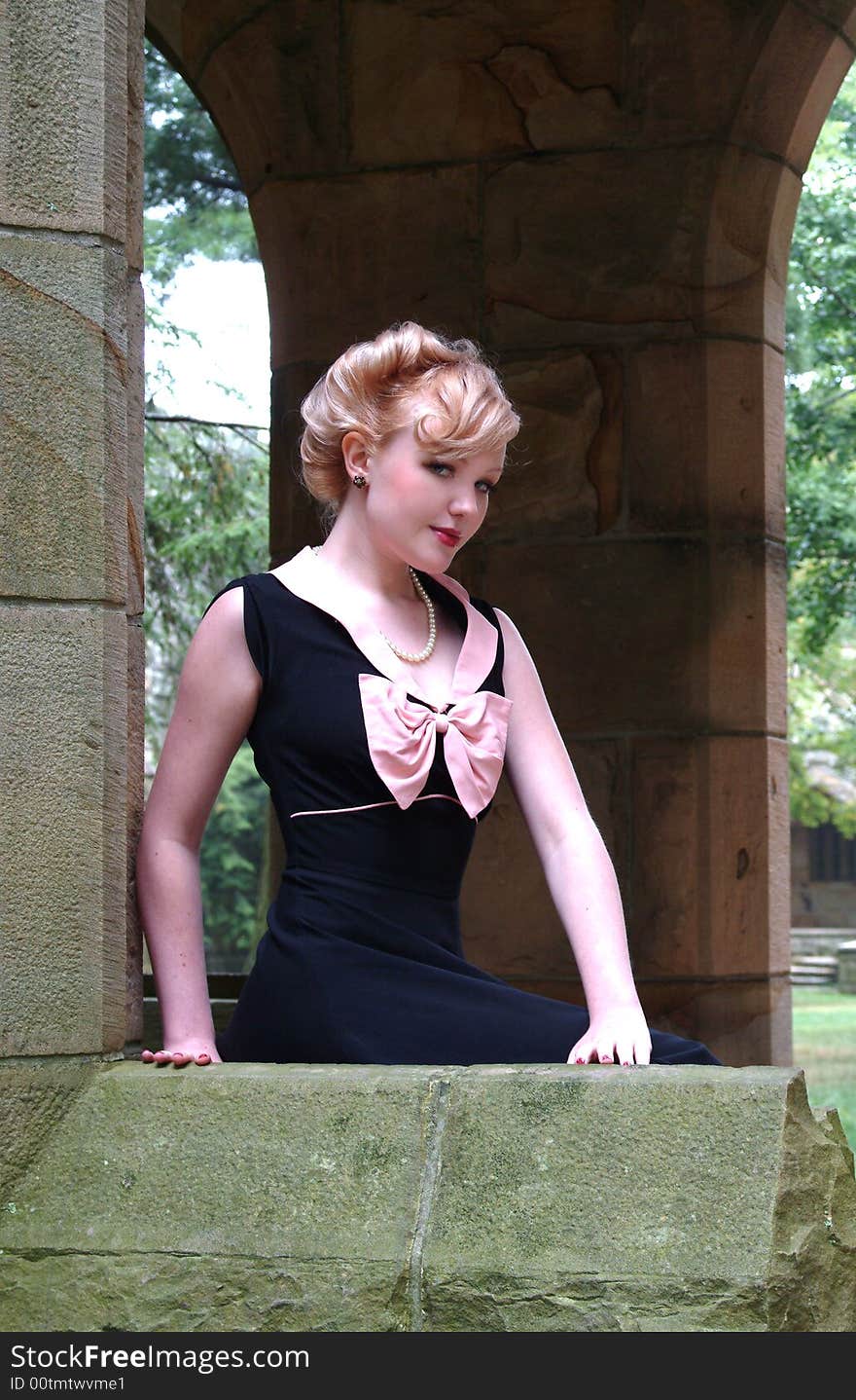 Young blond woman leaning on stone wall. Young blond woman leaning on stone wall