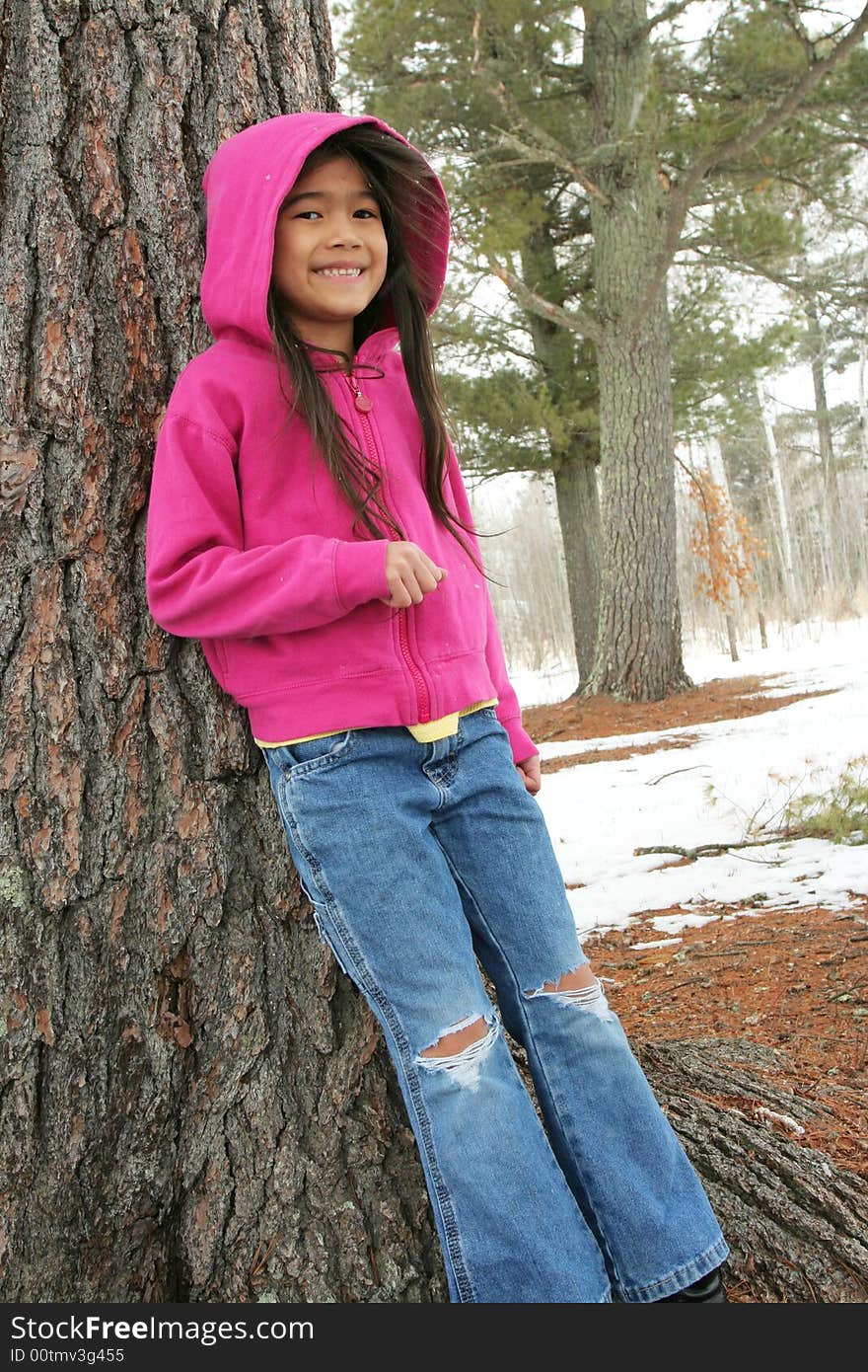 Six year old girl standing under tree in winter. Six year old girl standing under tree in winter