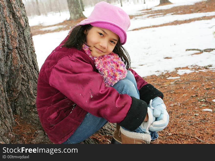 Nine year old girl enjoying sitting under tree in winter. Nine year old girl enjoying sitting under tree in winter