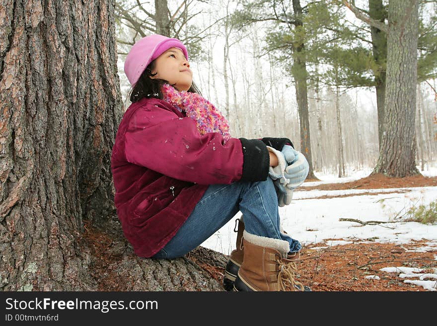 Nine year old girl sitting outdoors in winter