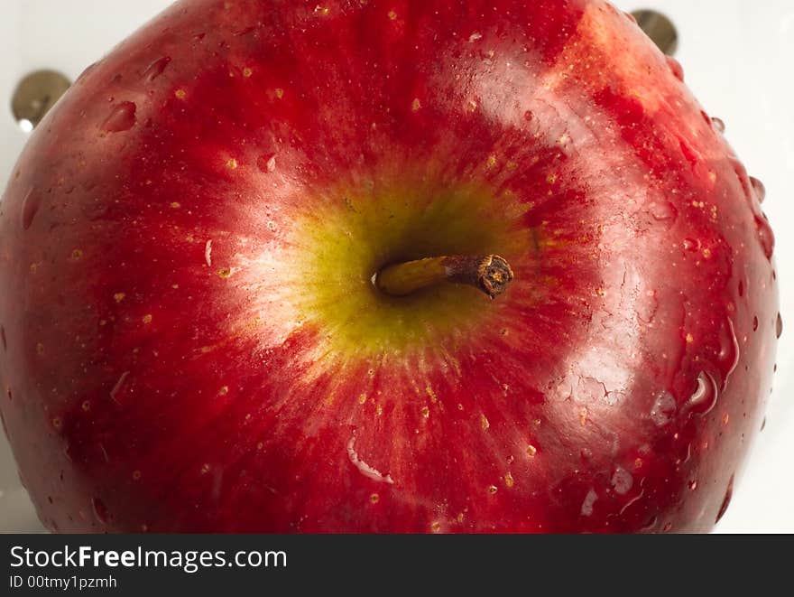 Close up red apple and stem on white isolated background.