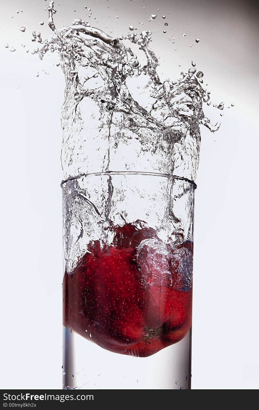 Apple splashing in glass of water