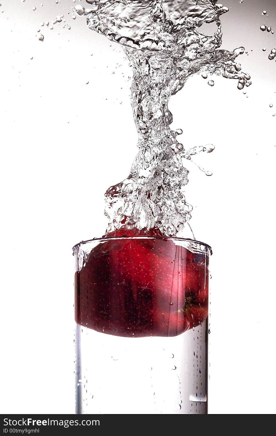 Apple splashing in glass of water