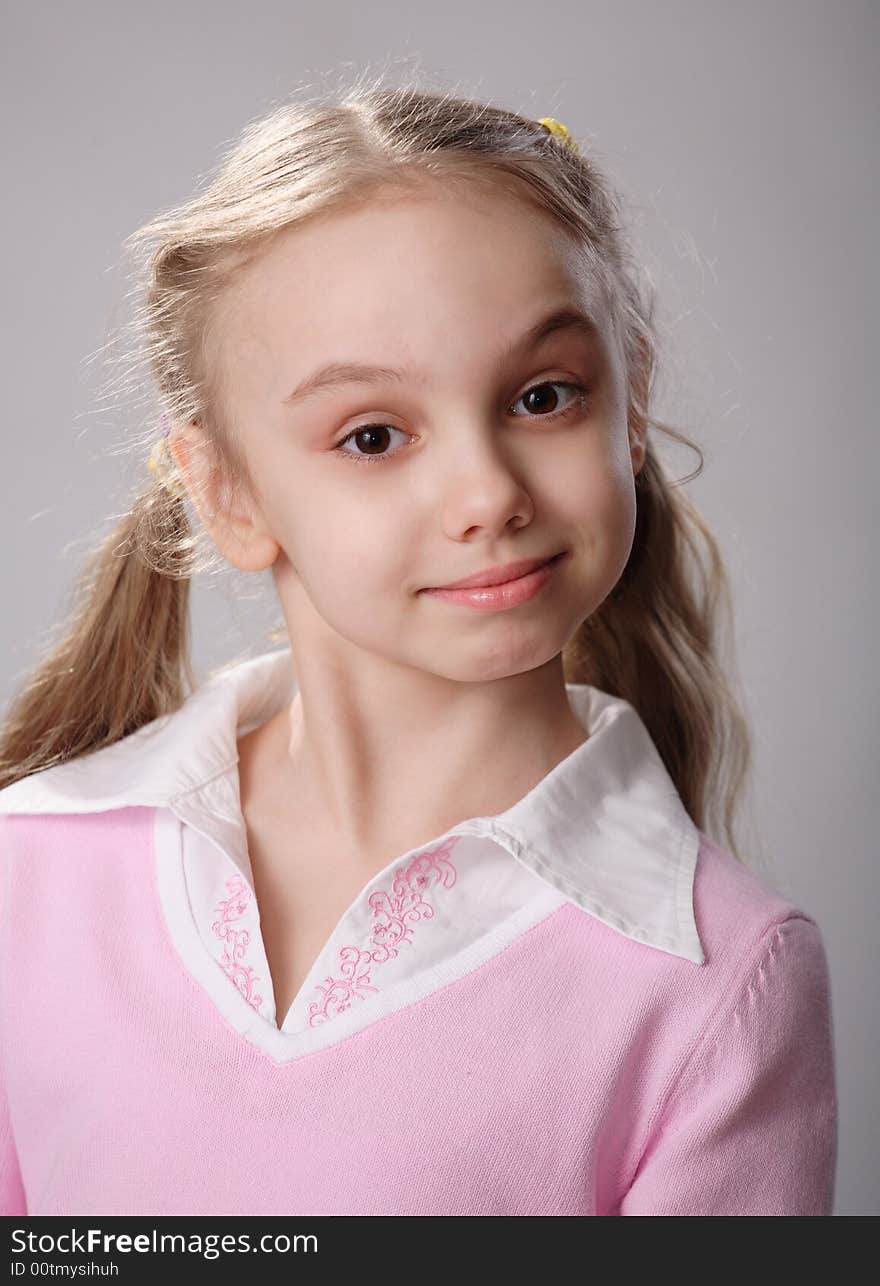 A studio shot of a cute little girl on a gray background